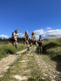 4 randonneurs sur une piste dans une prairie sautant en l'air