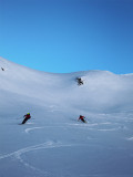 Skieur descendant dans la poudreuse, vue de loin